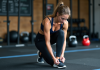 Comment préparer le Murph CrossFit : stratégies d’entraînement et conseils pratiques Femme en préparation de CrossFit dans une salle de sport