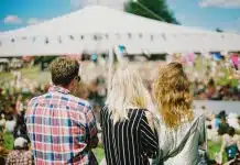 three person's standing front of field