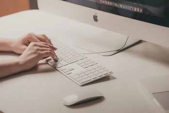 person typing on Apple keyboard